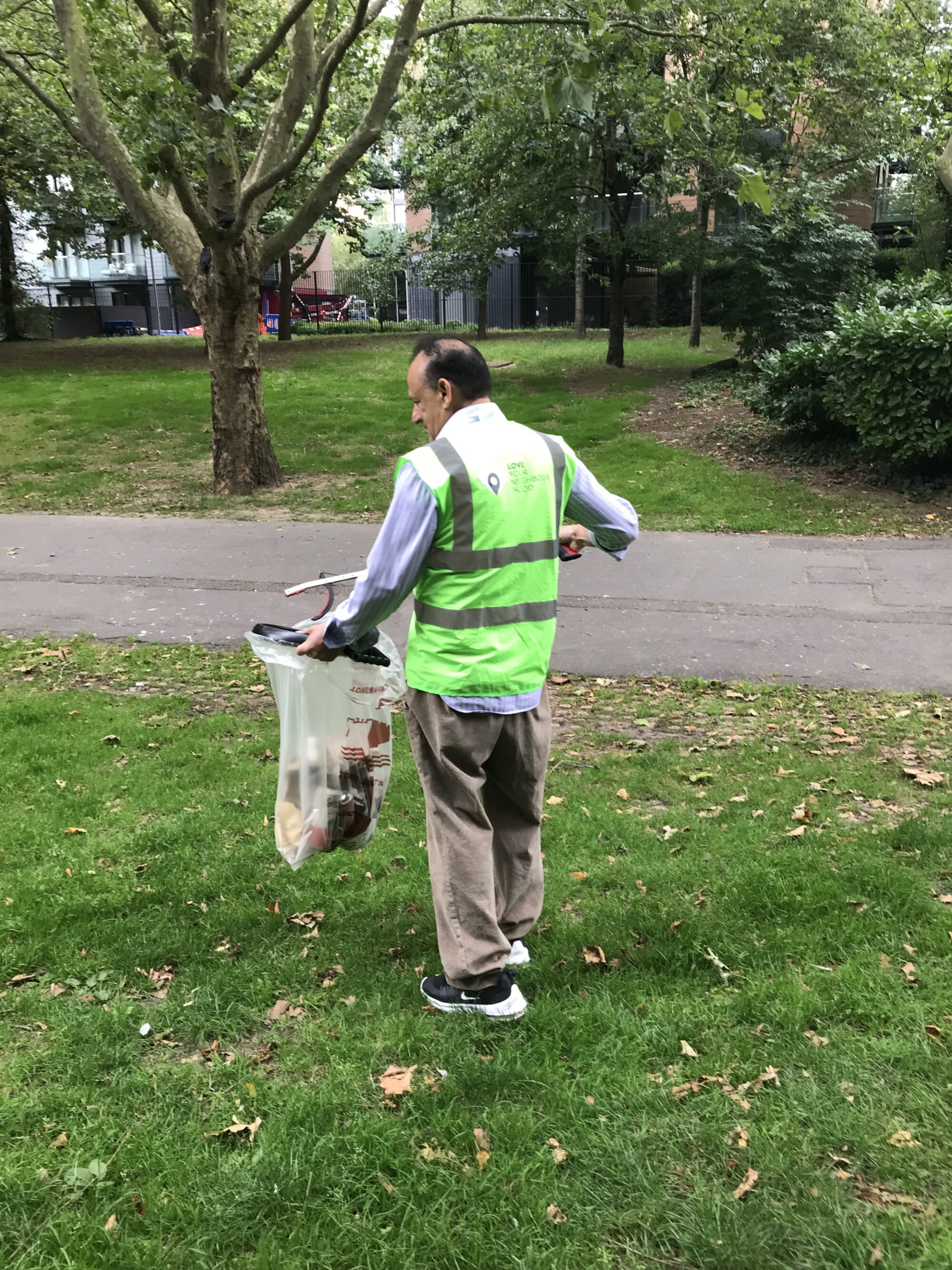 Abdul picking up litter in the park.