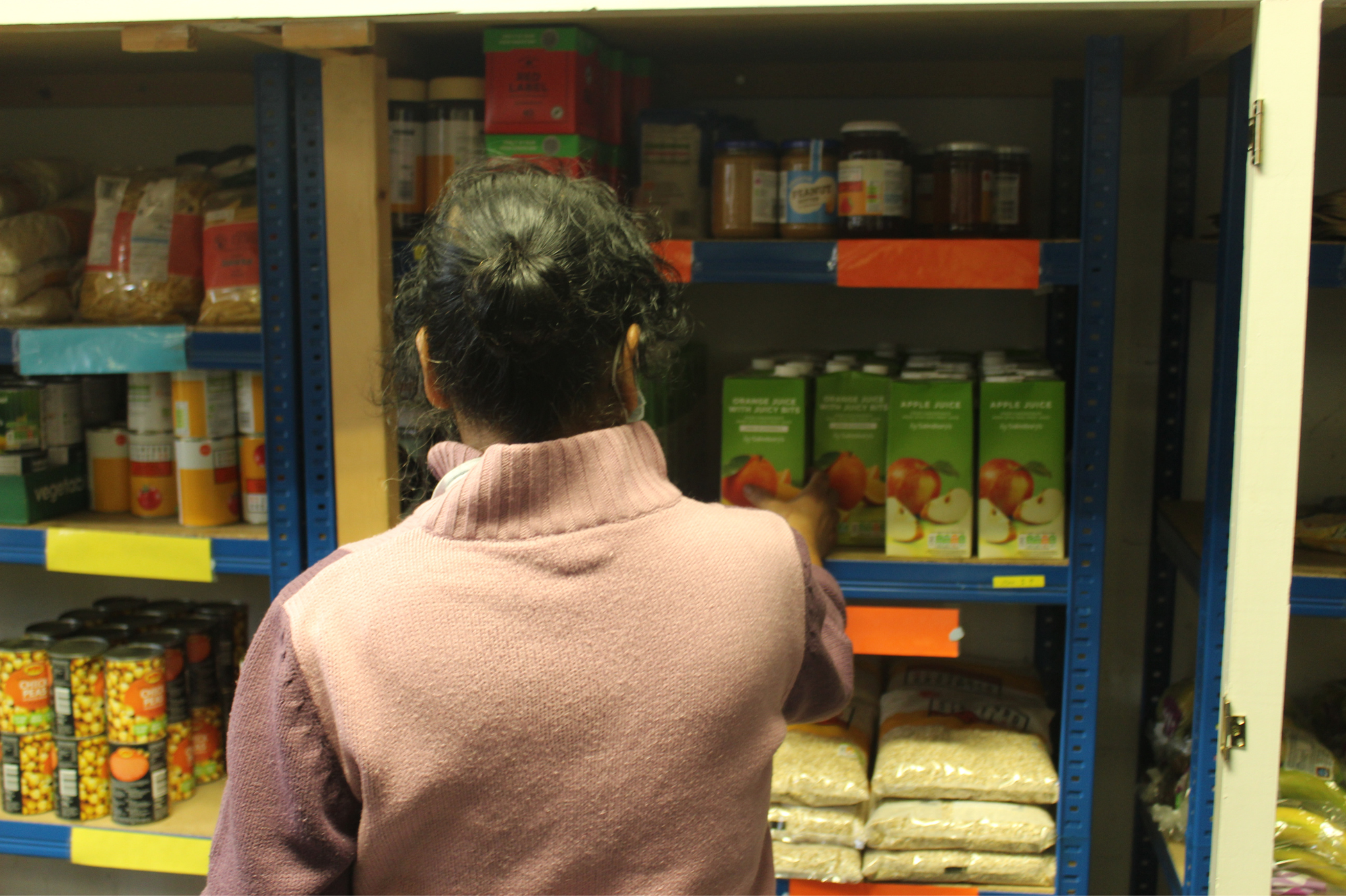 A volunteer stocking the shelves of the JRS Shop